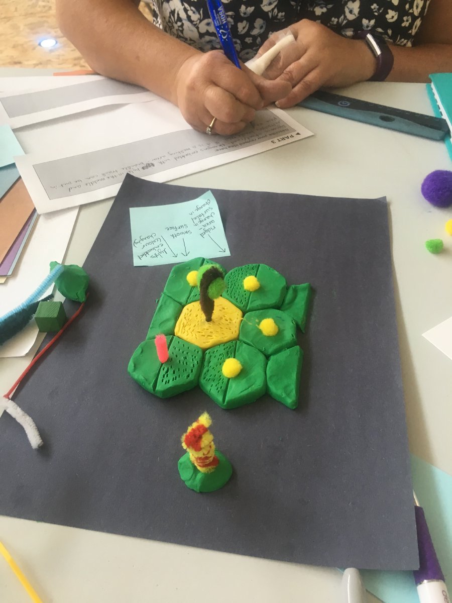 A participant from the group Sweet Streets building a prototype of a hexagonal paver that is embedded with a retractable braille trail for tactile feedback